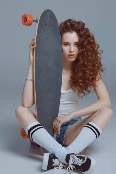 Stylish young woman with skateboard — Stock Photo