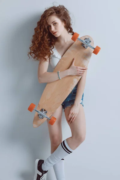 Хипстерская девушка со скейтбордом — стоковое фото
