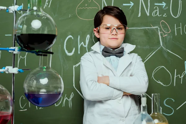 Boy in lab coat and protective glasses — Stock Photo