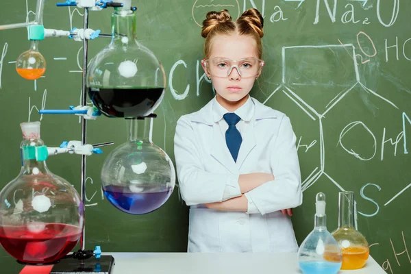 Girl in lab coat and protective glasses — Stock Photo