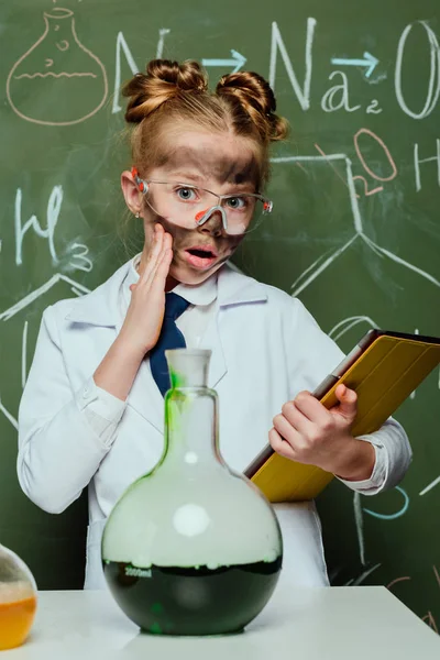 Girl in lab coat with tablet — Stock Photo