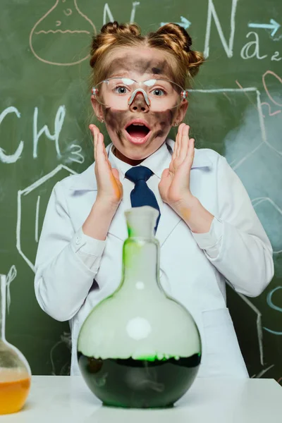 Chica en bata de laboratorio con frasco - foto de stock