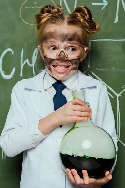 Chica en bata de laboratorio con frasco - foto de stock