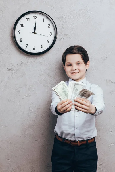 Bambino sorridente che mostra denaro — Foto stock