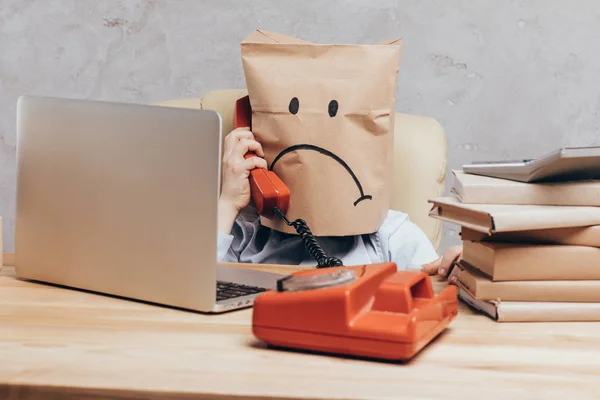 Bambino con sacchetto di carta in testa con telefono — Foto stock