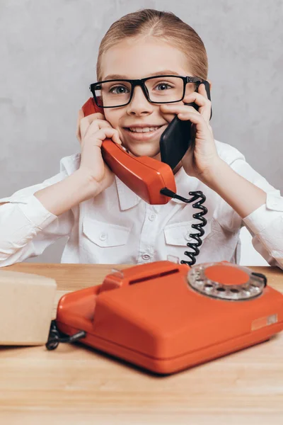 Kid with smartphone and telephone — Stock Photo