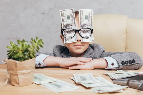 Niño pequeño con dinero en el lugar de trabajo - foto de stock