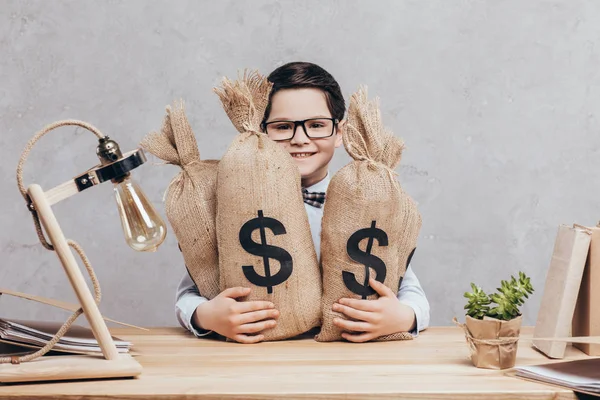 Niño pequeño con bolsas de dinero - foto de stock