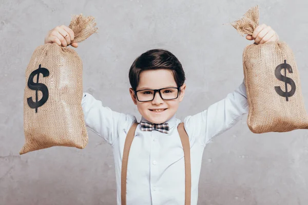 Niño pequeño con bolsas de dinero - foto de stock