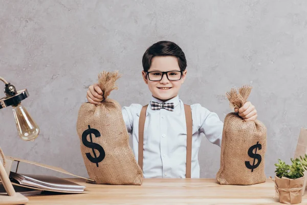 Niño pequeño con bolsas de dinero - foto de stock