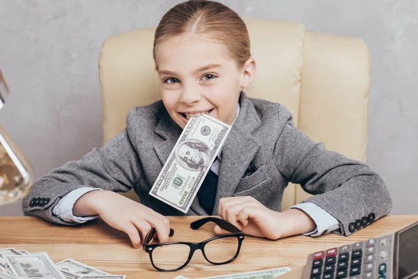 Bambino piccolo con soldi sul posto di lavoro — Foto stock