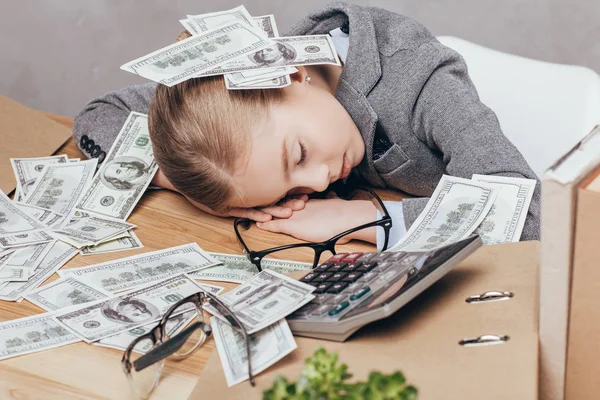 Дитина спить на робочому місці з грошима — стокове фото