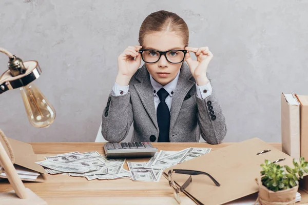 Niño calculando dinero en el lugar de trabajo - foto de stock