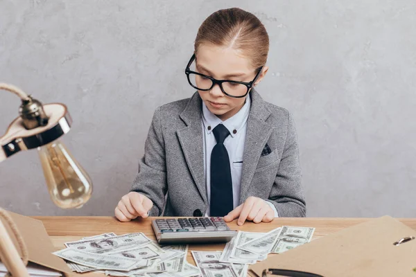 Niño calculando dinero en el lugar de trabajo - foto de stock