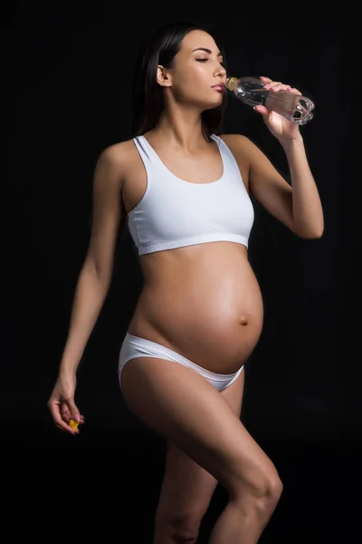 Pregnant woman drinking water — Stock Photo