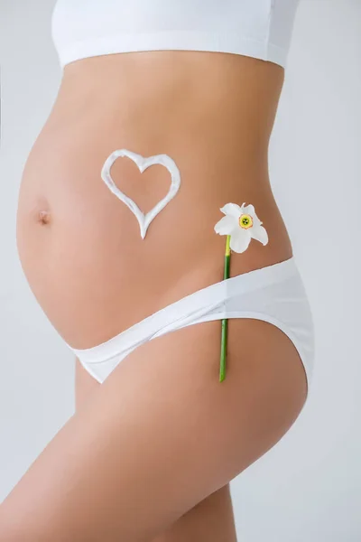 Barriga grávida com flor e coração — Fotografia de Stock