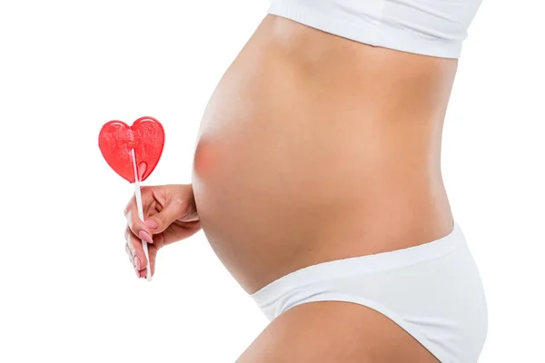 Pregnant woman with lollipop — Stock Photo