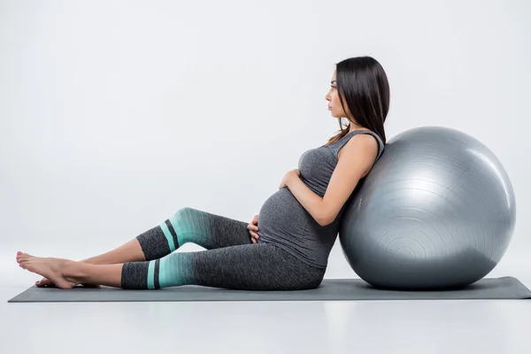 Mujer embarazada con pelota de fitness - foto de stock