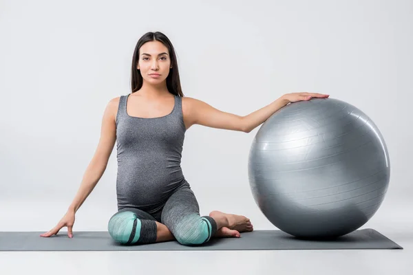 Mujer embarazada con pelota de fitness - foto de stock