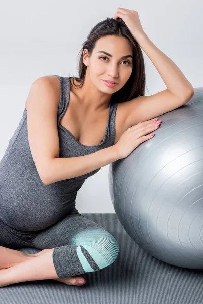 Mujer embarazada con pelota de fitness - foto de stock