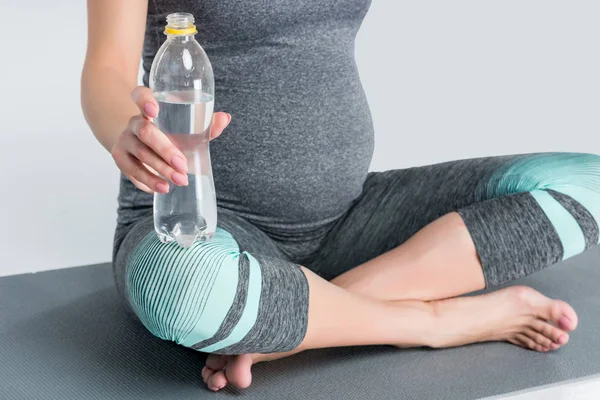 Mujer embarazada con botella de agua - foto de stock