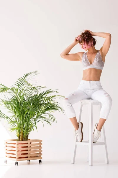 Femme souriante assise sur un tabouret de bar — Photo de stock