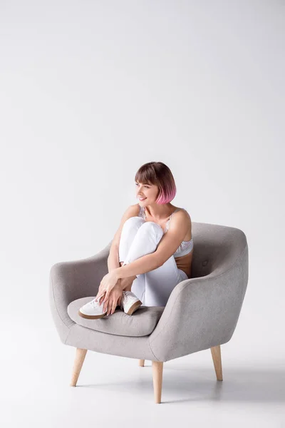 Улыбающаяся женщина сидит в кресле — стоковое фото