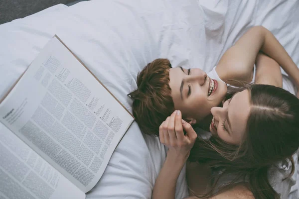 High angle view of young lesbian couple cuddling in bed — Stock Photo