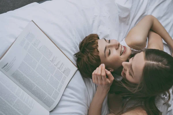 Vue grand angle de jeune couple lesbien câlins au lit — Photo de stock