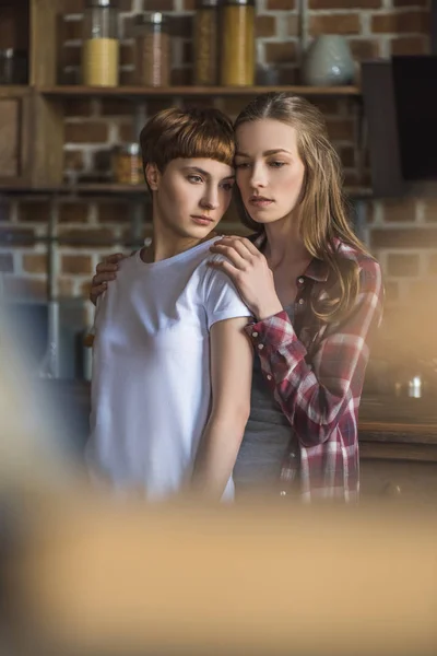 Beautiful young lesbian couple on kitchen at home — Stock Photo