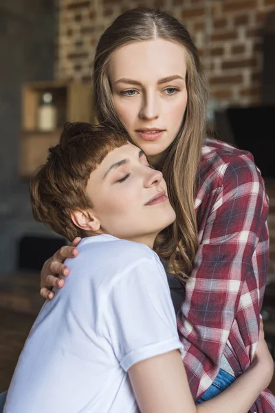 Young lesbian couple embracing on kitchen — Stock Photo
