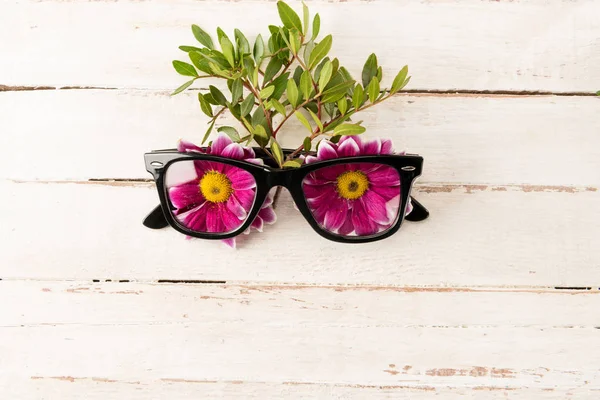 Gafas graduadas y flores rosas — Foto de Stock