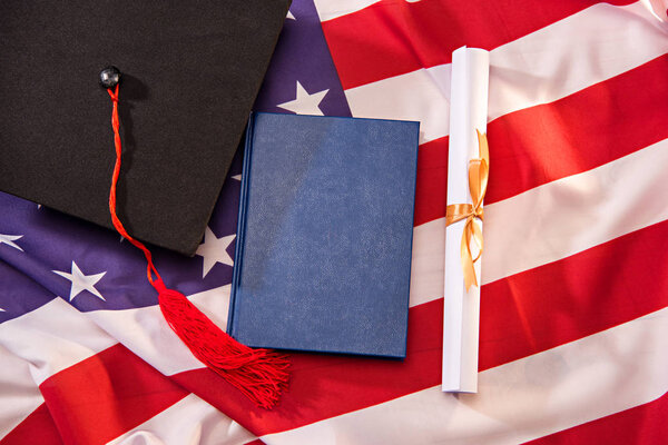 graduation cap and diploma on usa flag