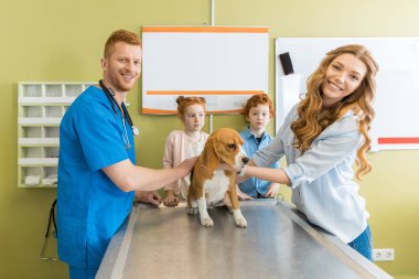 Woman, children with dog at veterinary doctor  clipart