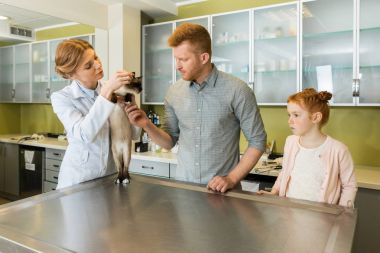 Man and his daughter at veterinary doctor clipart