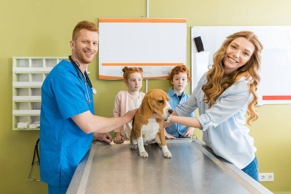 Woman, children with dog at veterinary doctor 