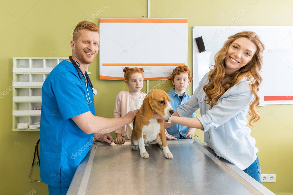 Woman, children with dog at veterinary doctor 