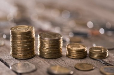 Stacks of coins on wooden tabletop clipart