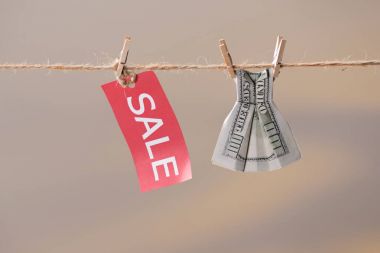 sale sign and dollar banknote on clothesline clipart