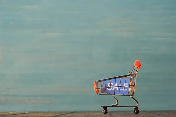 Carrinho de compras pequeno com sinal de venda — Fotografia de Stock