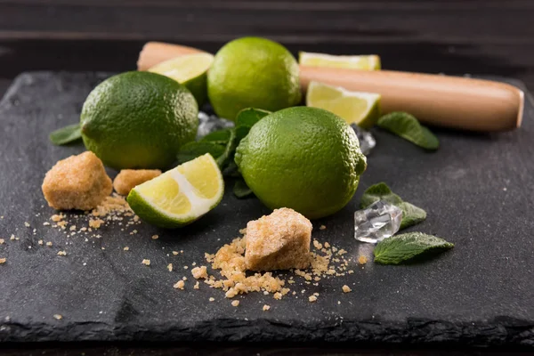 Lime slices with sugar and wooden squeezer — Stock Photo, Image