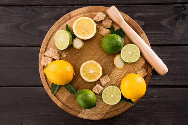 Lemons and limes with brown sugar — Stock Photo, Image