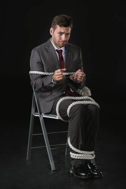 young businessman roped on to chair clipart