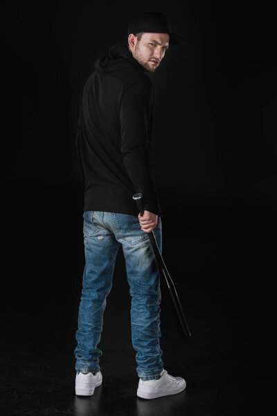 Молодой грабитель в зоопарке с бейсбольной битой
