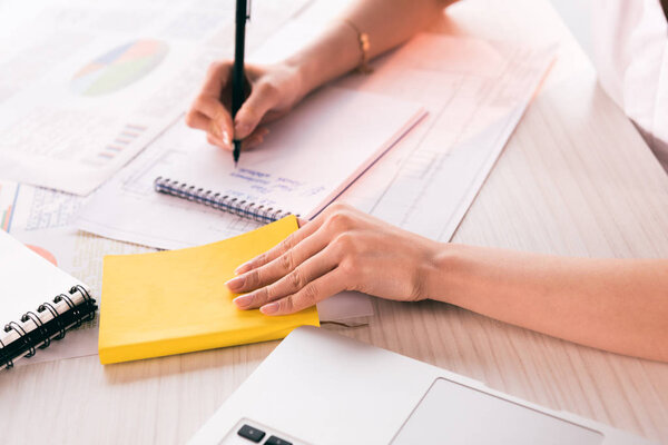 business woman writing at workplace on tabletop
