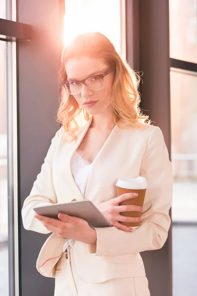 Affärskvinna håller digital tablet och kaffe — Stockfoto