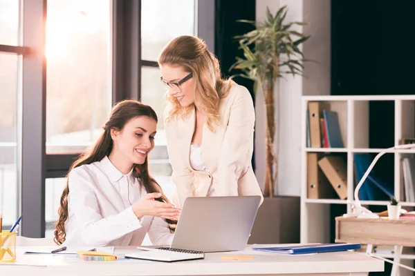 Jonge vrouwelijke ondernemers praten tijdens het werken op kantoor — Stockfoto