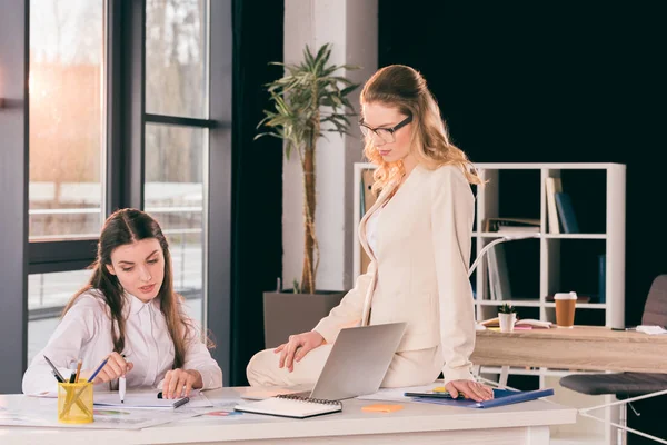 Jonge vrouwelijke ondernemers praten tijdens het werken op kantoor — Stockfoto