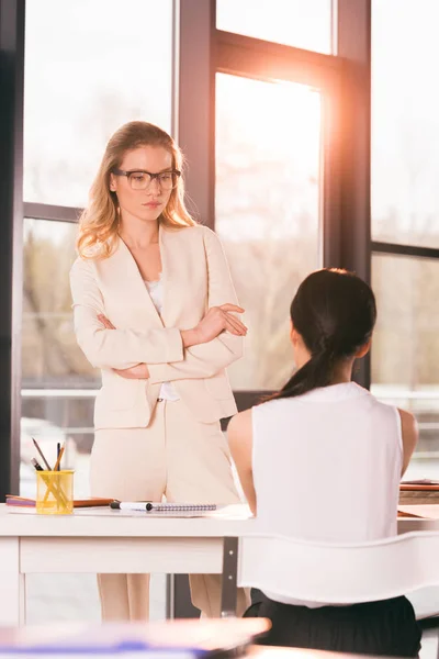 Бізнес-леді в формальному одязі розмовляють в офісі — стокове фото