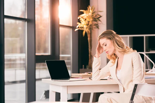 Exhausted businesswoman sitting in office — Stock Photo, Image